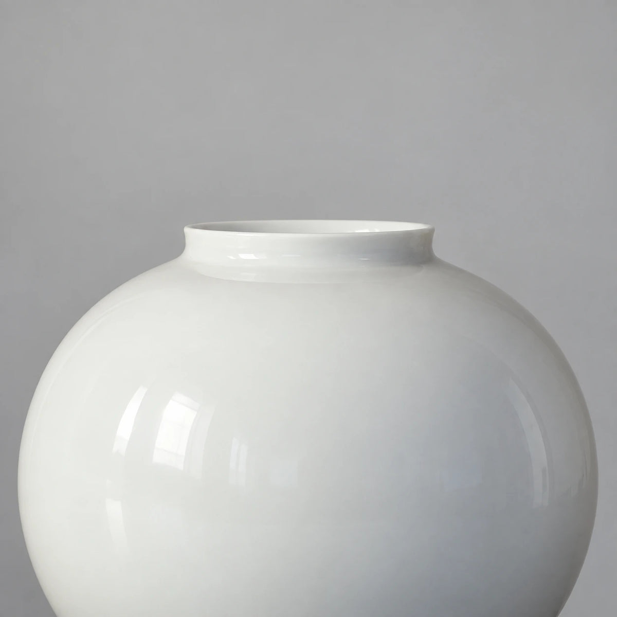 Close view of the medium moon vase showing its short flared rim and smooth glossy white ceramic shoulder.