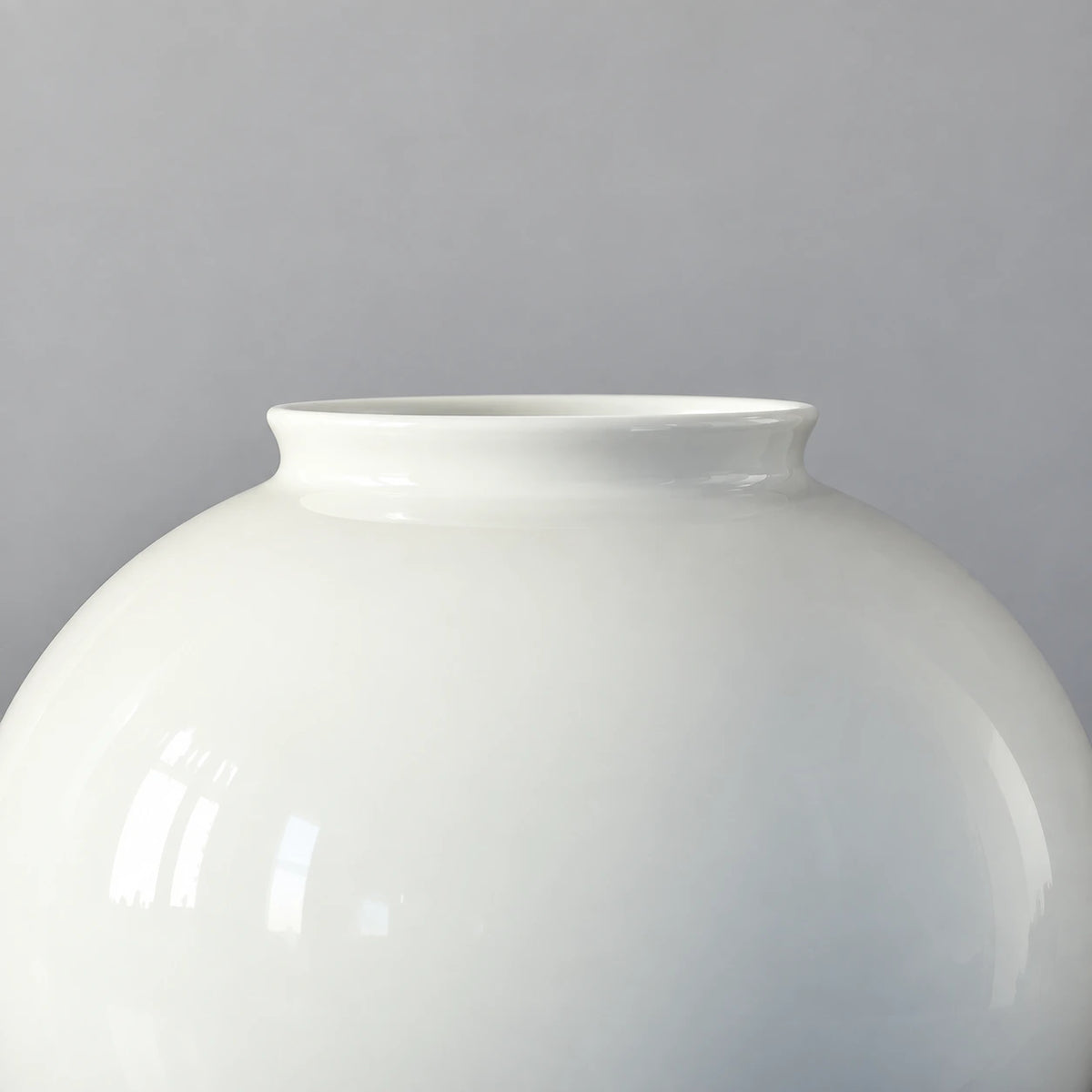 Close view of the large moon vase showing its short flared rim and smooth glossy white ceramic shoulder.