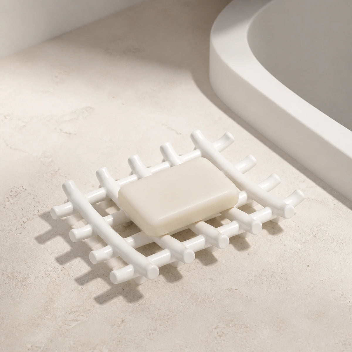 White branch-grid ceramic soap dish holding an ivory bar beside a sink