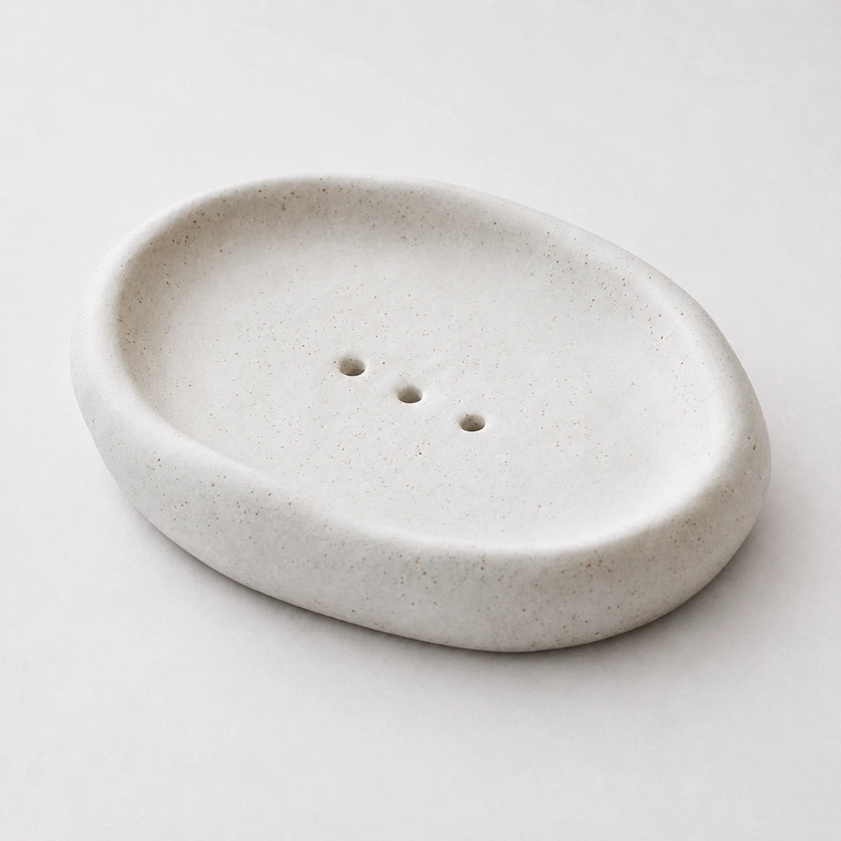 Close view of white speckled ceramic and three centered openings