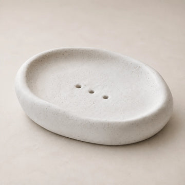 Empty Matte Speckled Cloud ceramic soap dish on pale warm stone