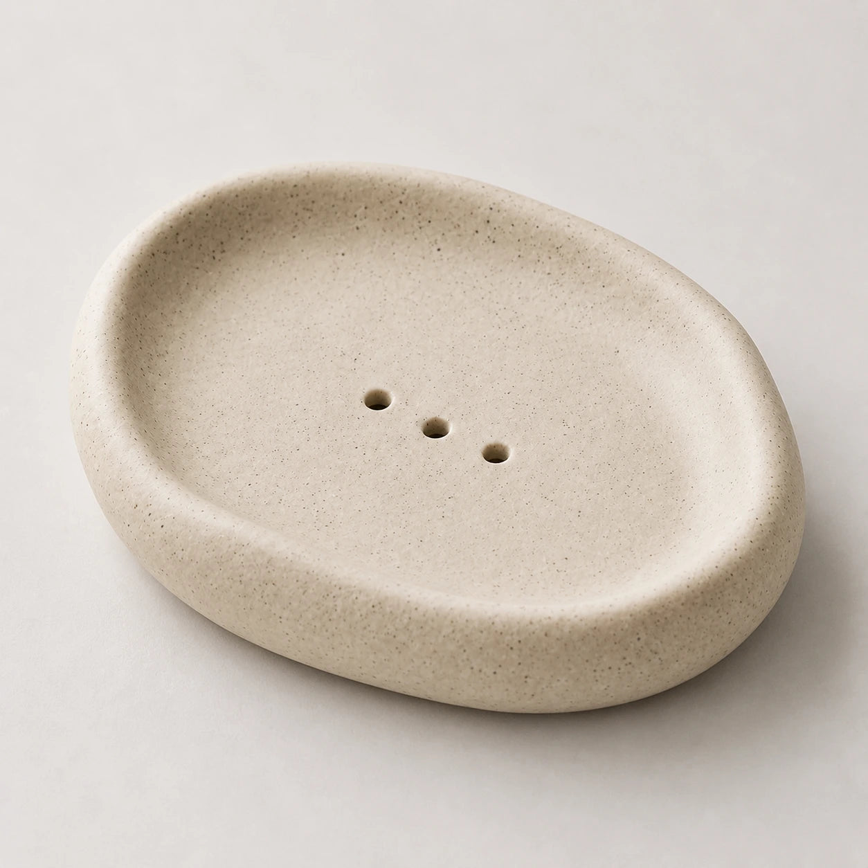 Close view of warm beige speckled ceramic and three centered openings