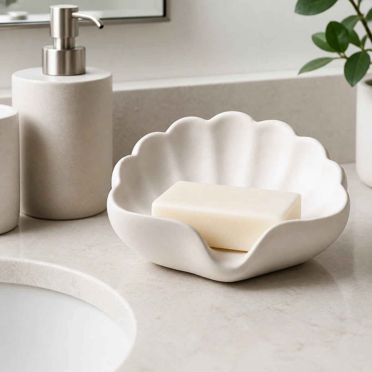 Pearl white shell soap dish holding a bar of soap beside a bathroom sink