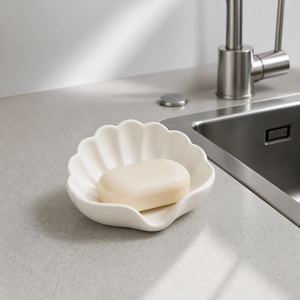 Pearl white shell soap dish holding a bar of soap beside a kitchen sink