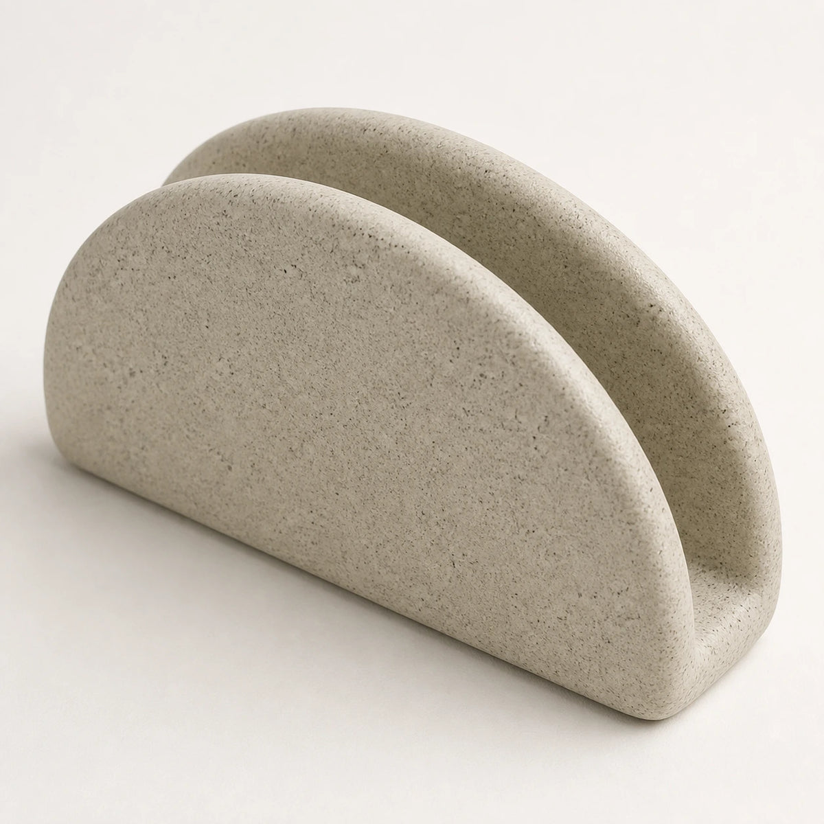 Close view of two ceramic walls, center slot, and fine speckles on a napkin holder