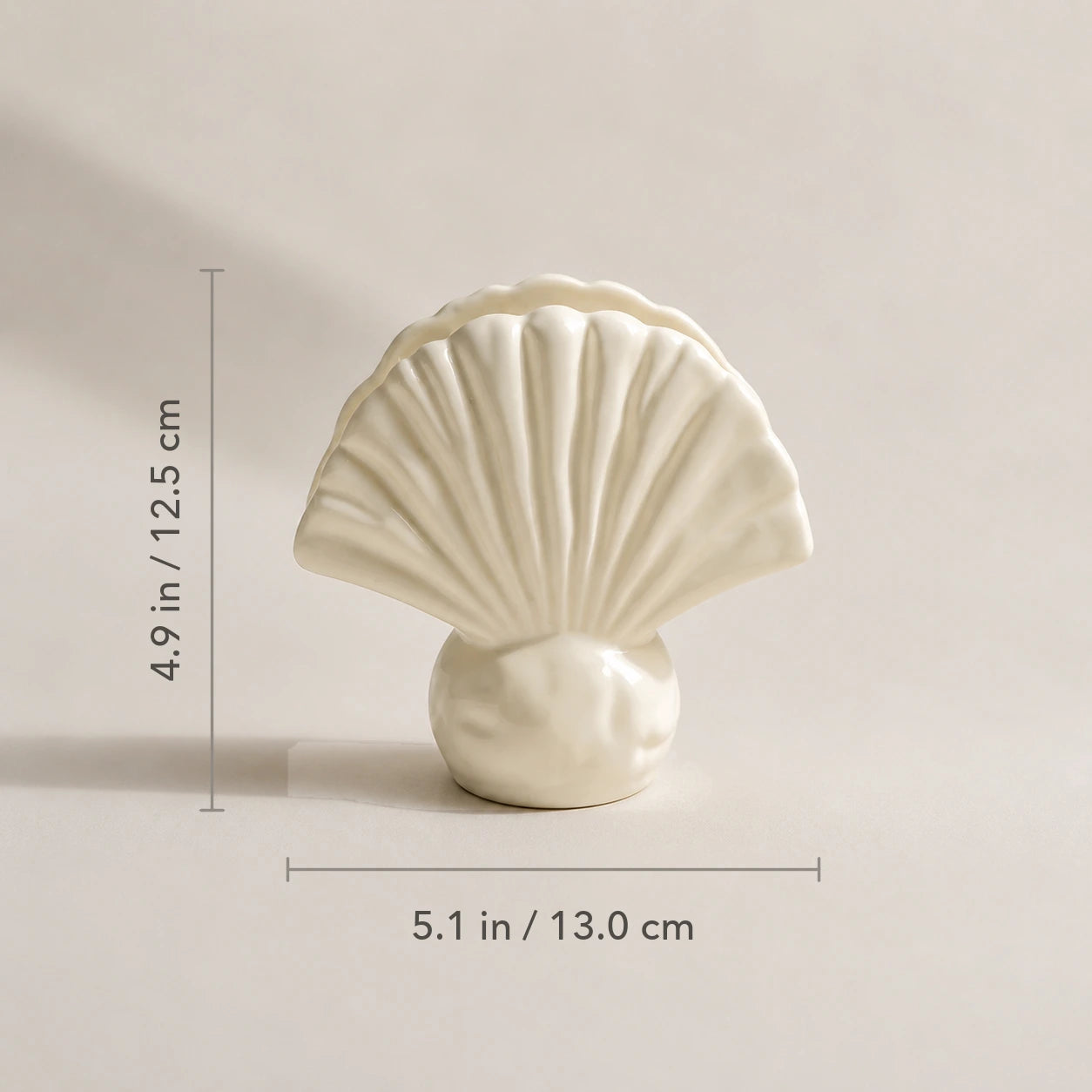 Elfenbeinfarbener Keramik-Serviettenhalter in Muschelform mit Maßen von 13 cm Breite und 12,5 cm Höhe