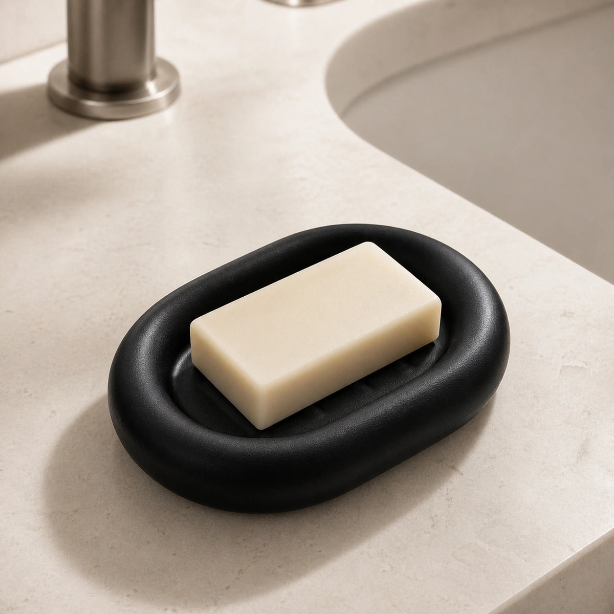 Matte black ceramic soap dish holding a soap bar beside a bathroom sink