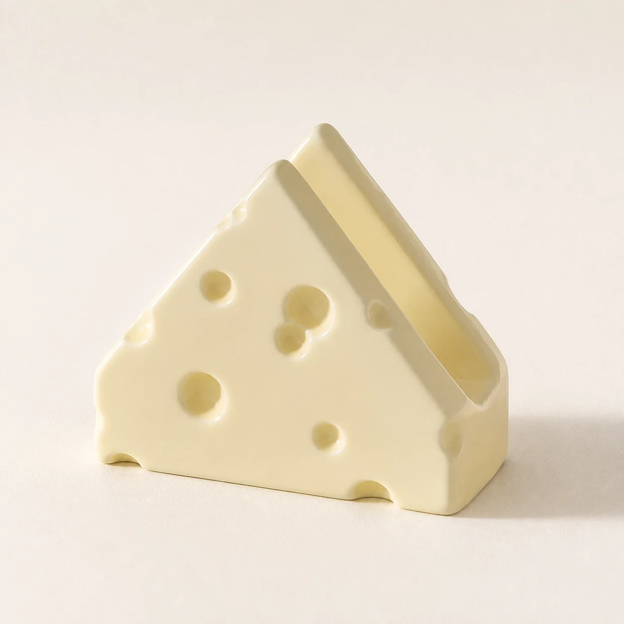 Butter Cream Swiss Cheese ceramic napkin holder in a three-quarter view