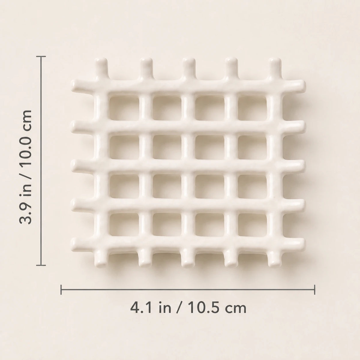 Porte-savon en treillis blanc mat vu de face avec les dimensions indiquées de 10,5 cm de largeur et 10 cm de hauteur